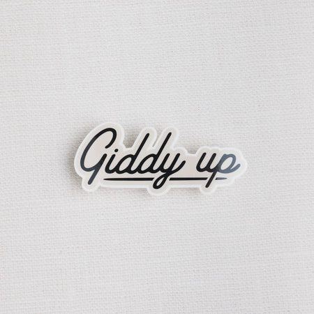 Sticker with black text cursive writing saying, “Giddy Up”.