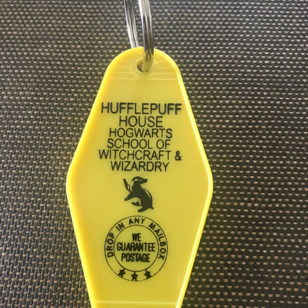 Yellow vintage style motel key fob with black text featuring Hufflepuff House from Harry Potter.