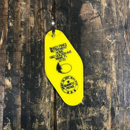 Yellow vintage style motel key fob with black text featuring the famous Golden Girls retirement home.