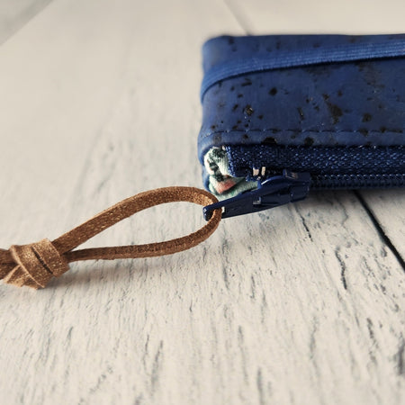 Cork rectangle pencil case in blue color with blue zipper and blue banding along the bottom center. Brown twine loop attached to zipper.