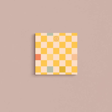 Square pad with yellow, pink, tan and aqua squares in a checkerboard pattern.