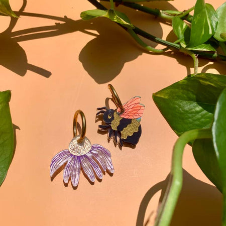 Set of earrings in the image of a bumble bee and a purple flower.