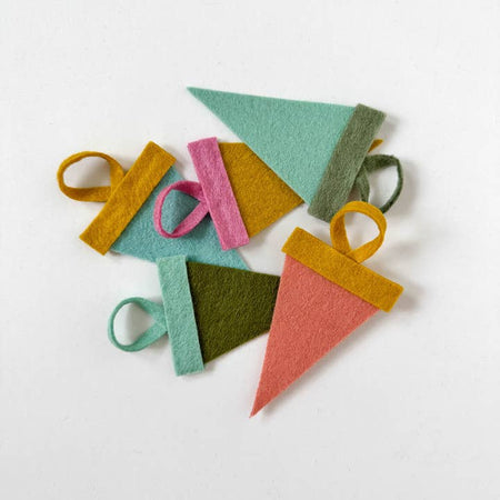 Mini felt pennants in muted pastel colors with custom white text saying, “SATX”. 