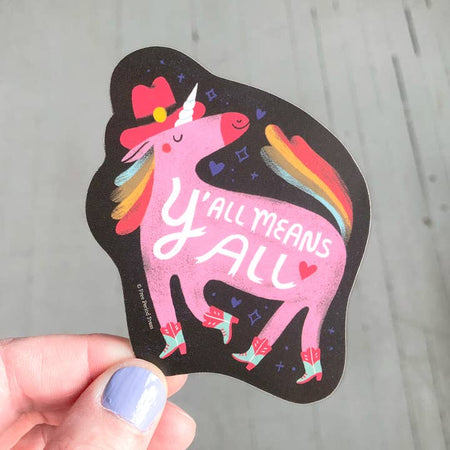 Sticker in the image of a pink unicorn with a rainbow mane and tail wearing a pink cowboy hat and cowboy boots. White text saying, “Y’All Means All”.