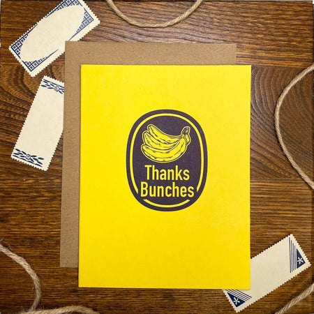 Yellow card with image of a banana brand sticker with yellow text saying, “Thanks Bunches”. A brown kraft envelope is included.