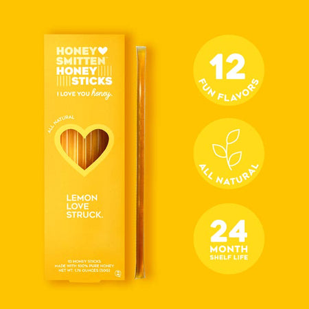 Honey sticks packaged in a vertical yellow box with a heart shape cut out in center. White text saying, “Honey Smitten Honey Sticks Lemon Love Struck”.