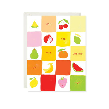 White card with colored checker board pattern and various fruits in checker board squares. Red text saying, “You Are the Cherry on Top”. A white envelope is included.