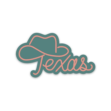 Green sticker with pink script text saying, “Texas”. The top of the T has an outline of a cowboy hat.