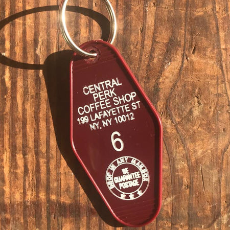 Maroon vintage style motel key fob with white text featuring Central Perk coffee shop from the television show Friends.