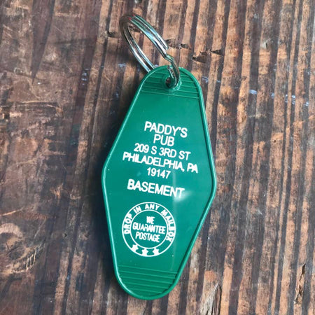 Green vintage style motel key fob with white text featured in It's Always Sunny in Philadelphia.