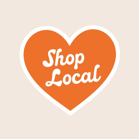 Sticker with image of a red heart in center. White text in center of heart saying, “Shop Local”.