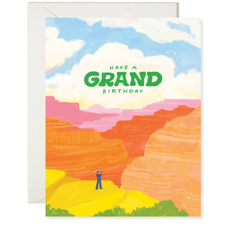 Card with image of a scene from the Grand Canyon with a man looking through binoculars. Green text saying, “Have A Grand Birthday”. A white envelope is included.