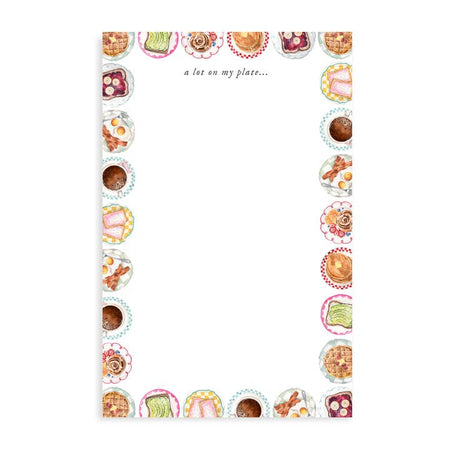 White notepad with black text saying, “A Lot on My Plate” in top center. Images of all types of breakfast food on plates around the border. Foods such as: pancakes, cinnamon roll, pastry tarts, bacon and eggs, avocado toast and peanut butter toast.