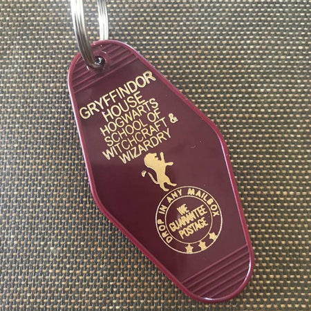 Maroon vintage style motel key fob with gold text featuring Gryffindor House from Harry Potter.