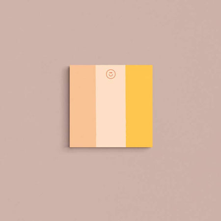 Square pad with salmon pink, light pink and yellow vertical stripes and a smiley face in the top center.