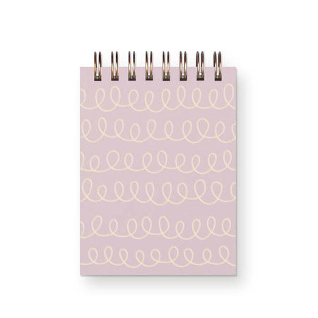 Light purple notebook with ivory colored swirls vertically striped across notebook. Gold coil binding across top,