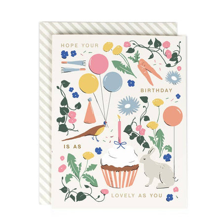 White card with images of a bunny, orange carrots, birthday balloons, a peacock, and pink flowers. Gold foil text saying, 