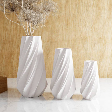 White vase with vertical slanted contoured lines.