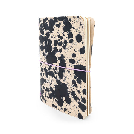 Leather notebook with black speckled paint splatter design.