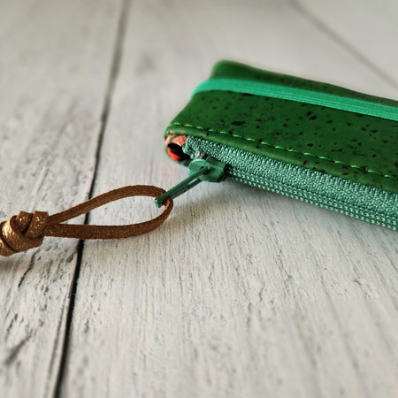 Cork rectangle pencil case in green color with green zipper and green banding along the bottom center. Brown twine loop attached to zipper.