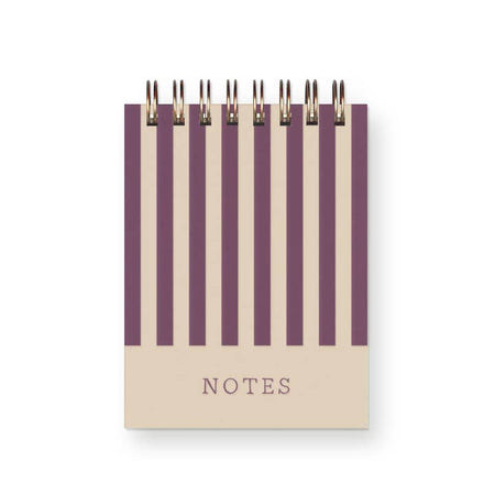 Ivory notebook with purple vertical stripes. Purple text saying, 