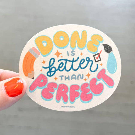 White circle sticker with colored puffy text saying, “Done is Better Than Perfect”. Images of a pencil and a paintbrush.