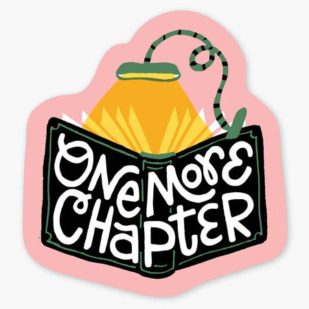 Pink sticker with black book with a green reading light attached to the top. White text on book saying, “One More Chapter”.