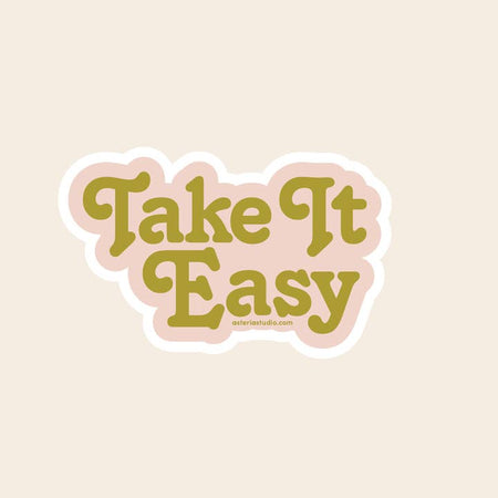 Sticker with pink background and green text saying, “Take It Easy”.