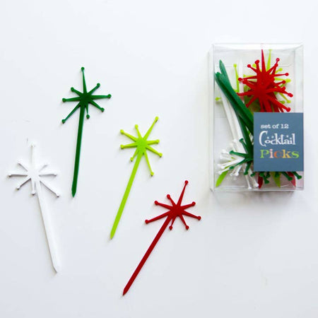 Green, red, and white cocktail picks in the image of a starburst design on the top and straight pointed pick on the bottom.