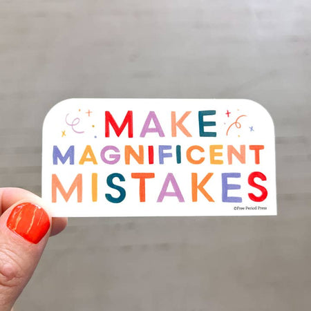 White sticker with rainbow text saying, “Make Magnificent Mistakes”. Images of stars and curly swirls.