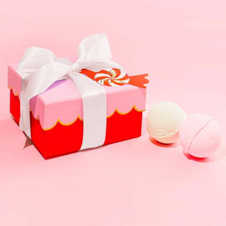 White and pink soap balls wrapped in a red box with a pink scalloped cover and tied with a white ribbon bow.