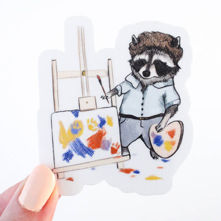 Image of a raccoon painter pretending to be famous painter Bob Ross with easel, paint palette, paint brush and colorful canvas.