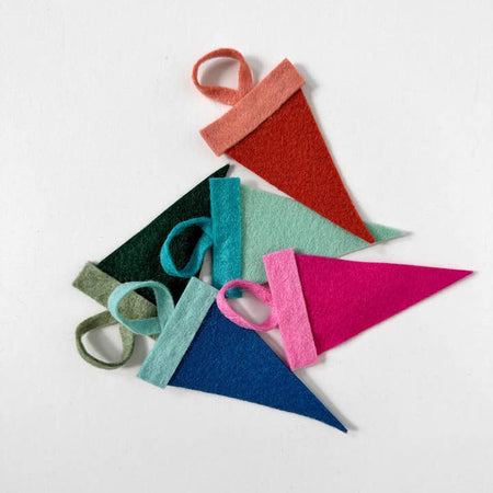 Mini felt pennants in monochromatic colors with custom white text saying, “Texas”. 