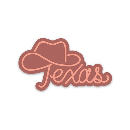 Red sticker with pink script text saying, “Texas”. The top of the T has an outline of a cowboy hat.