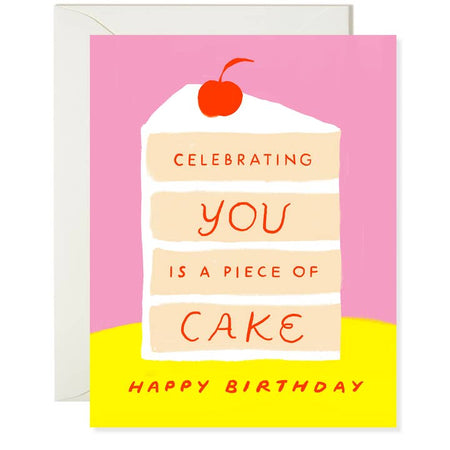 Pink card with image of a tall 4 layer piece of vanilla cake with white frosting and a cherry on top. Red text saying, “Celebrating You Is A Piece of Cake. Happy Birthday”. A white envelope is included.