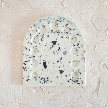 Paint palette made with white terrazzo stone speckled with blue, gray, and pick stone. 