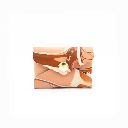 Small leather envelope with colorful marble swirl design in tans, browns, and whites with brass snap in center.