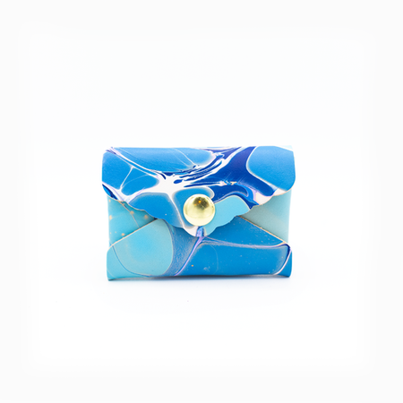 Small leather envelope with colorful marble swirl design in blues, whites and teals with brass snap in center.