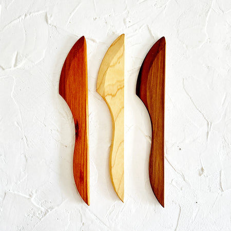 Wooden spreader knives in different shades of wood from light to dark.