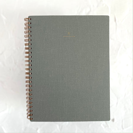 Gray textured cover with brass coil binding on left side.