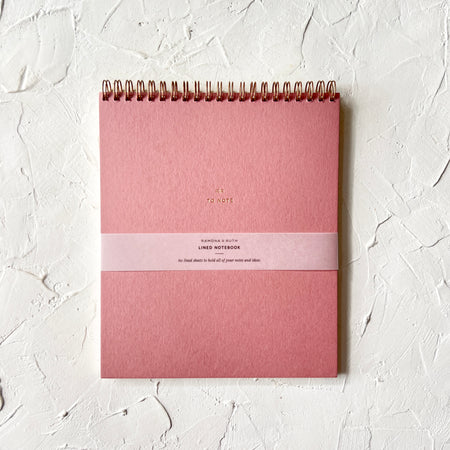 Pink notebook with gold foil text saying, 